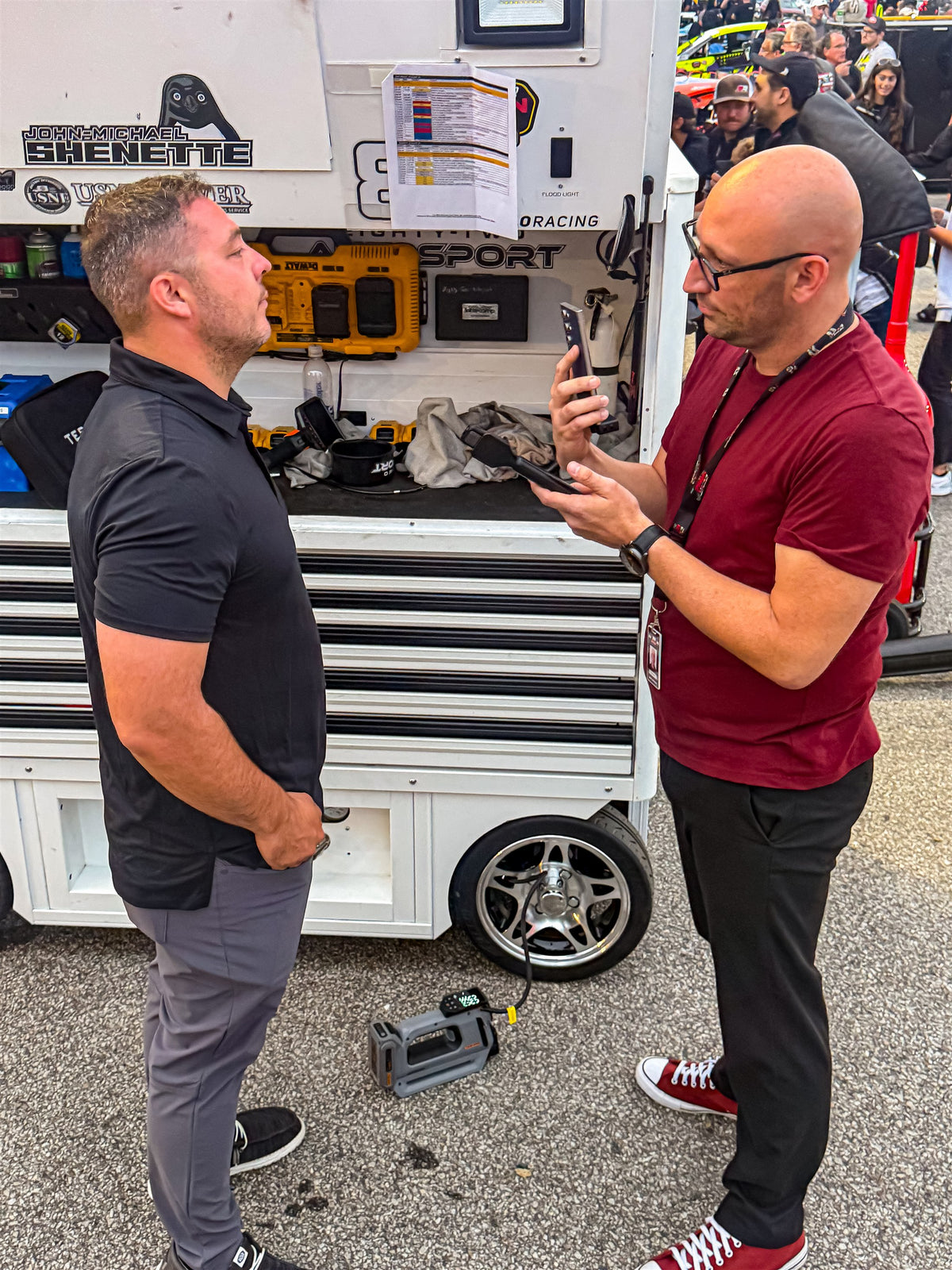 Trackside conversation with a grey Teslong tire inflator beside the equipment cart