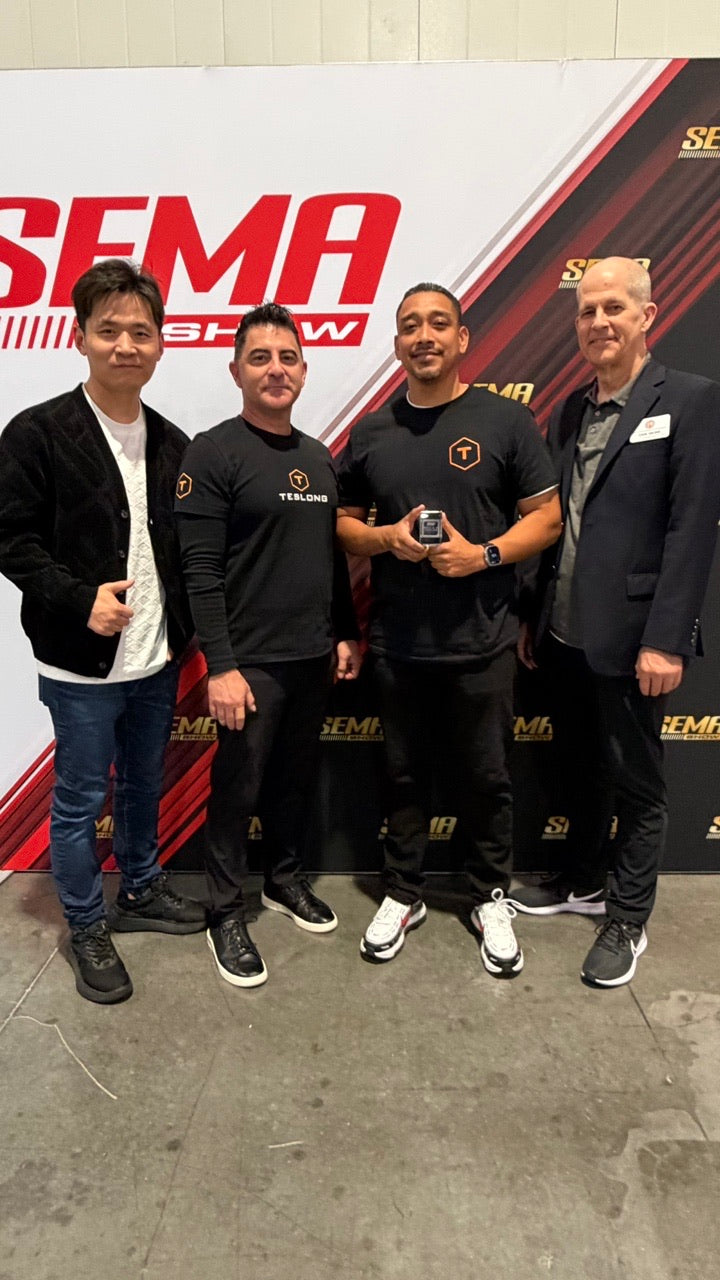 A group photograph at the SEMA Show backdrop